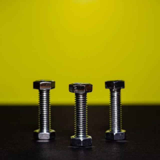 Three hex bolts on a yellow background