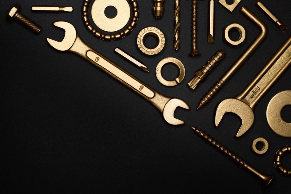 Brass wrenches and fittings on a black background