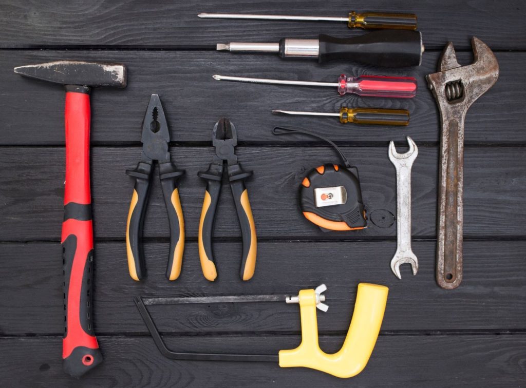 Hand tools laid out on dark wood