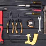 Hand tools laid out on dark wood