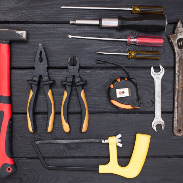 Hand tools laid out on dark wood