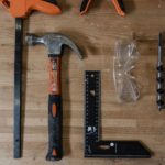 Hammer, set square and bits on a wooden table